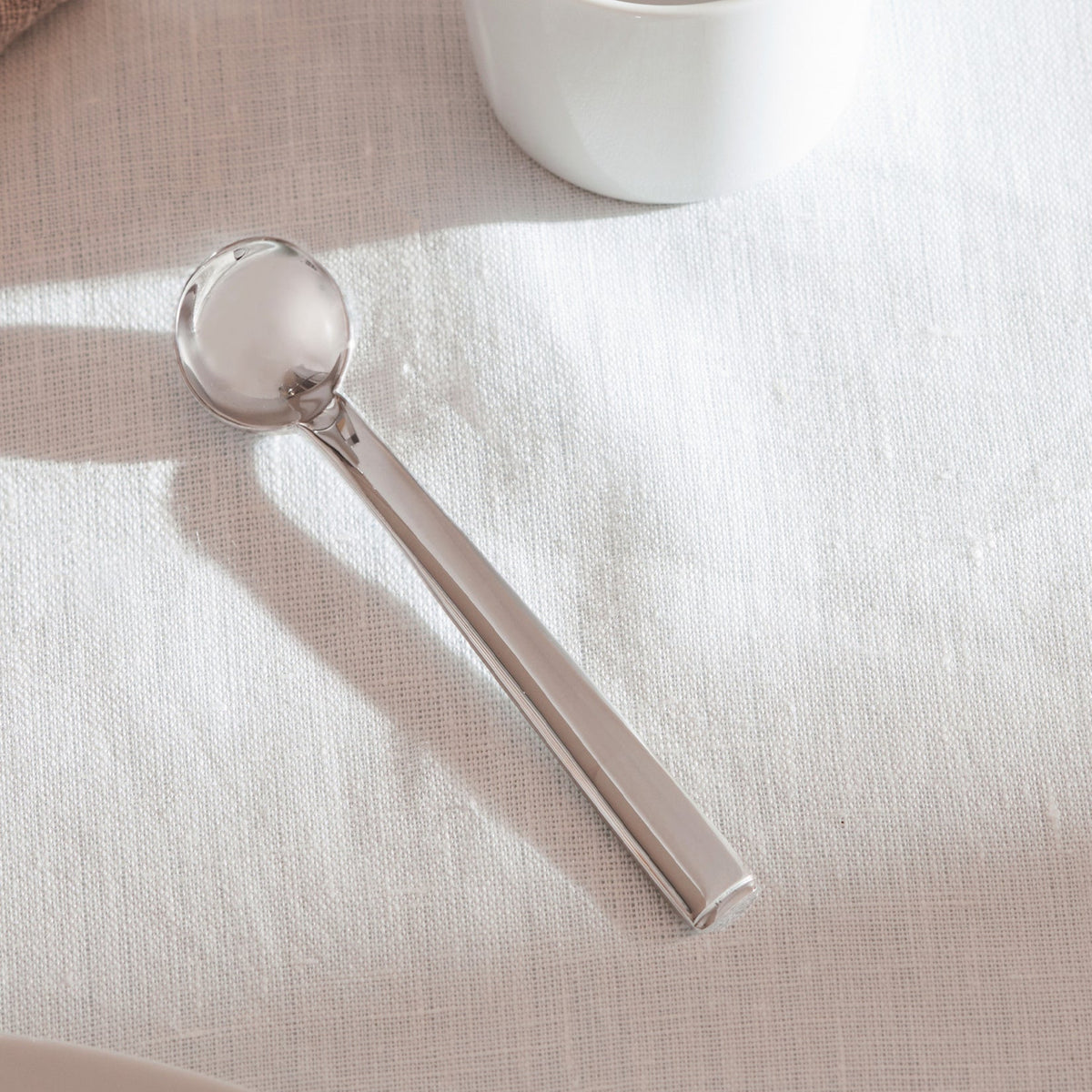 Alessi Rundes Modell theelepel JH01/7 op tafel
