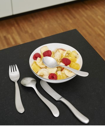 Pott Bonito kinderbestek met vork, mes en lepels bij een schaal fruit