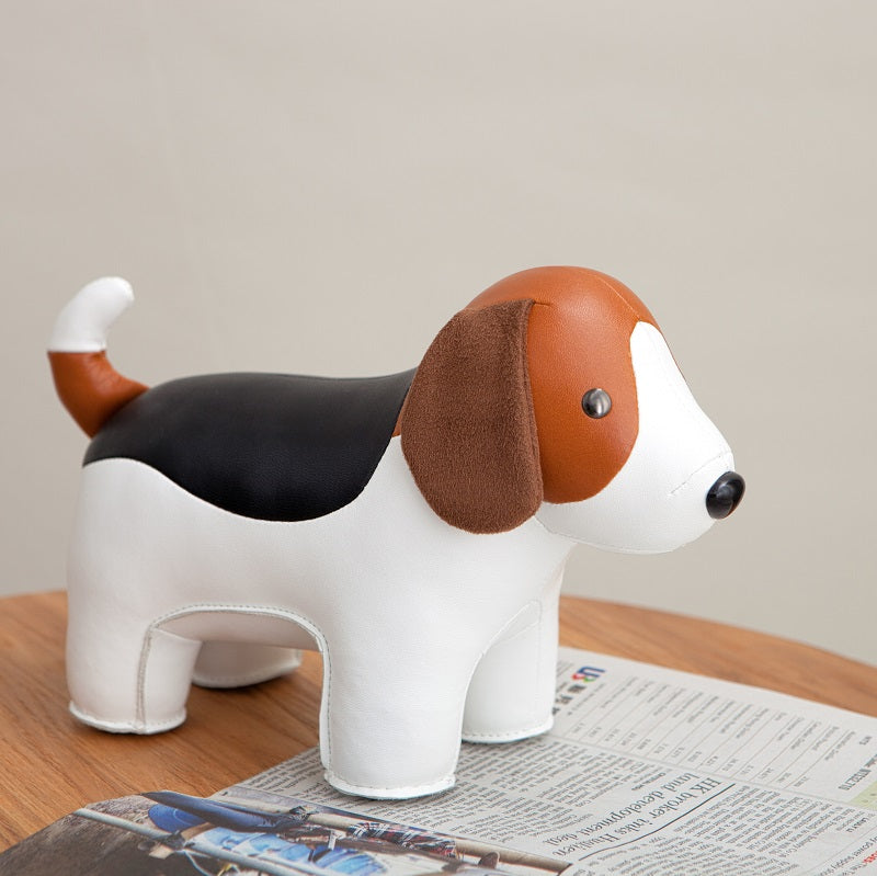 Kunstleder beagle boekensteun op een stapel papier, in wit, zwart en bruin.