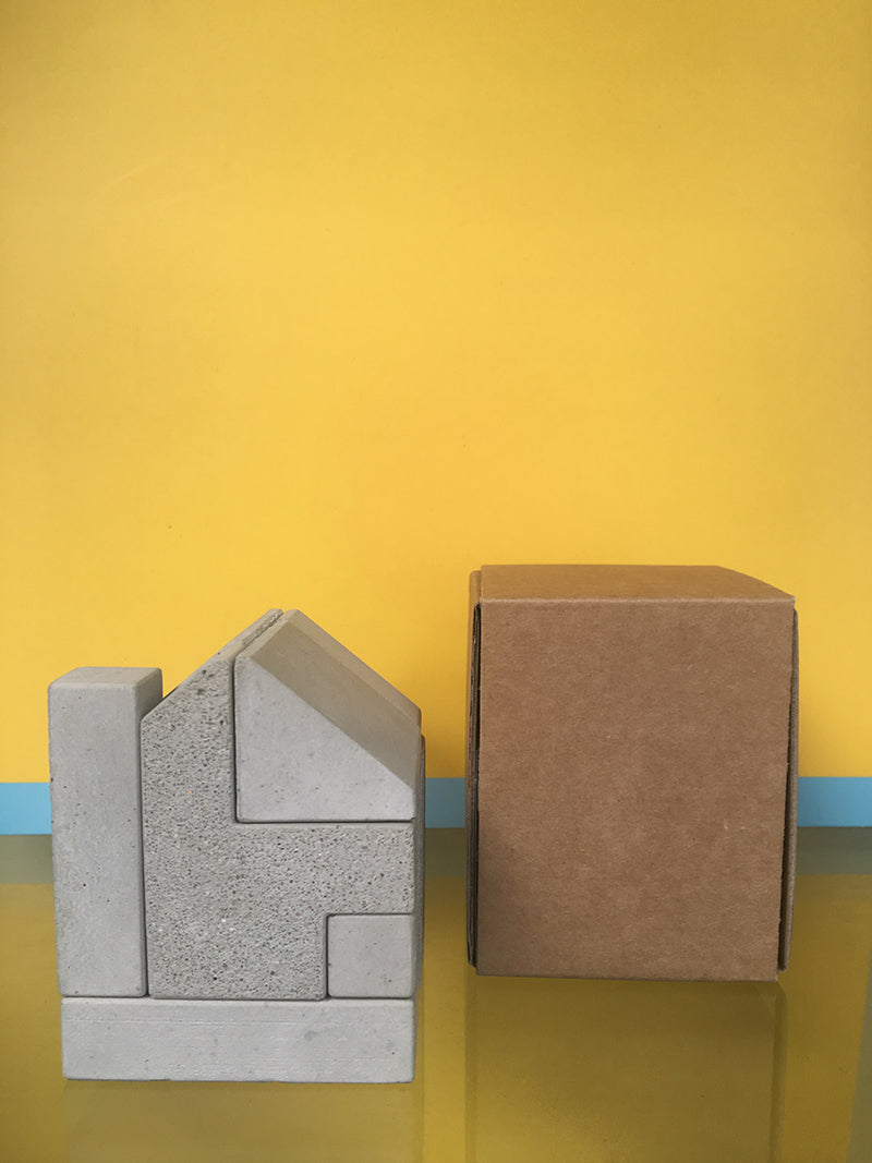 Alessi Big House bookend in concrete next to packaging