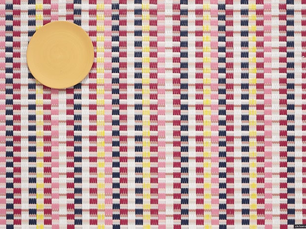 Placemat Heddle Pansy van Chilewich, geweven patroon in roze, rood en geel, detail met bord.