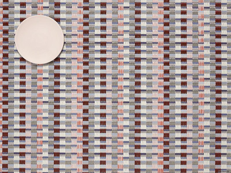 Heddle Dogwood placemat by Chilewich, woven pattern in red, coral and blue, with plate