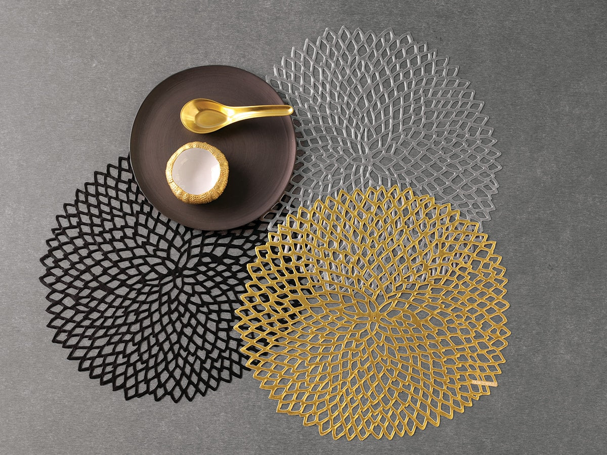 Mooie placemat Dahlia in goud, zwart en zilver naast elkaar, met servies op tafel
