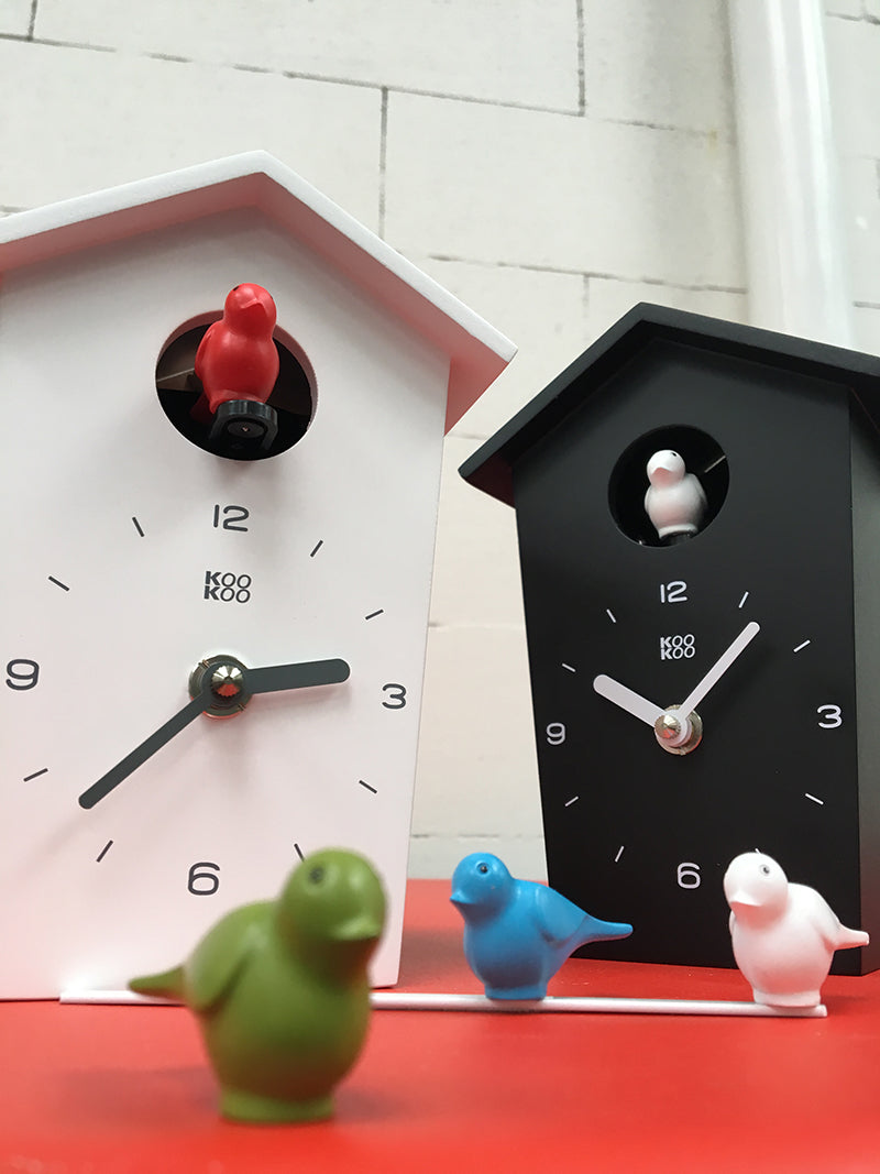 Kookoo Mini Birdhouse klokken in wit en zwart naast elkaar