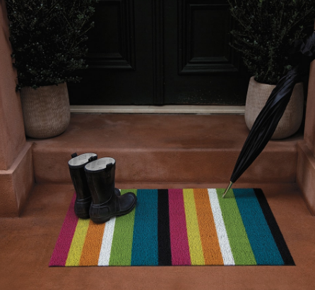 Bold Stripe Multi doormat by Chilewich, placed at a front door