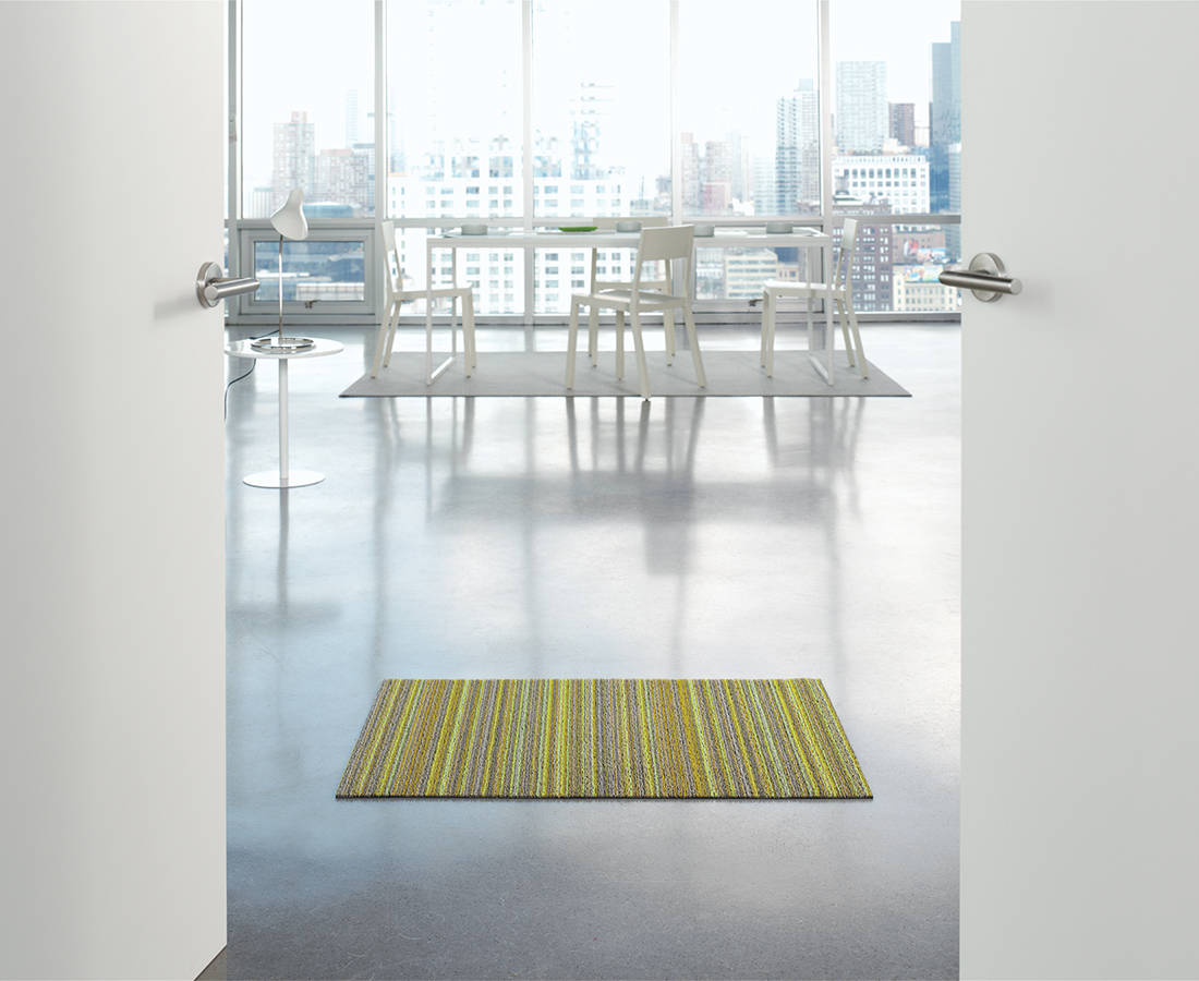 Chilewich doormat Skinny Stripe Citron in interior by door, yellow-green stripe
