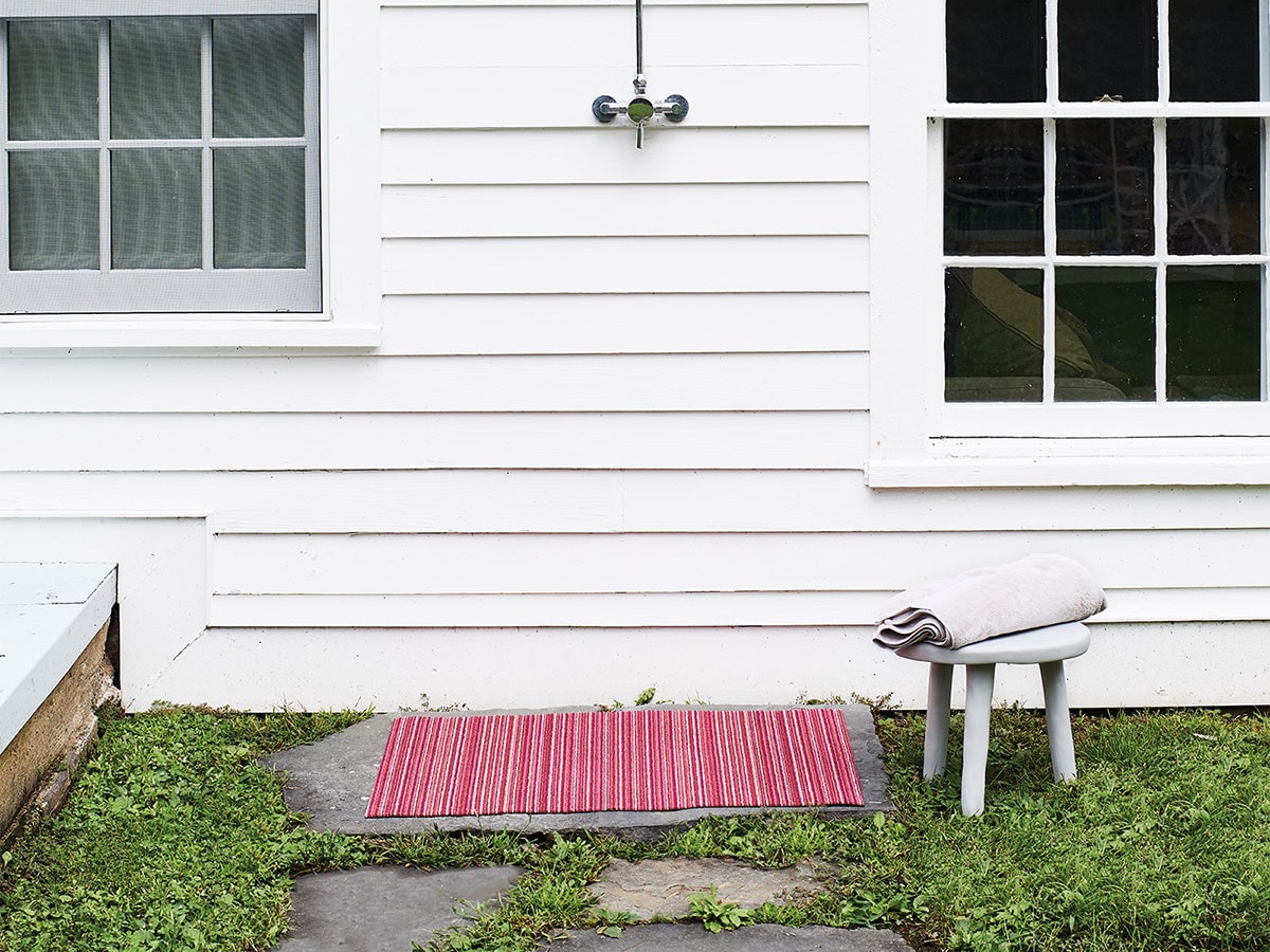 Skinny Stripe Raspberry doormat placed outdoors for use at an entrance