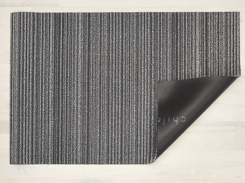 Chilewich deurmat Skinny Stripe Shadow, omgeslagen hoek toont vinyl onderlaag