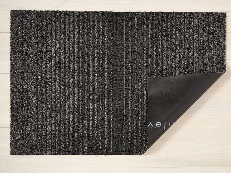 Detail van de vinyl onderlaag van de Chilewich deurmat Ombré Shag Plus, grijs