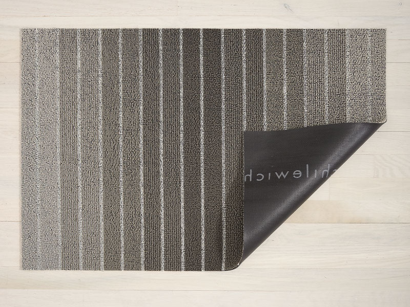 Chilewich deurmat Block Stripe, omgeslagen hoek toont vinyl onderlaag