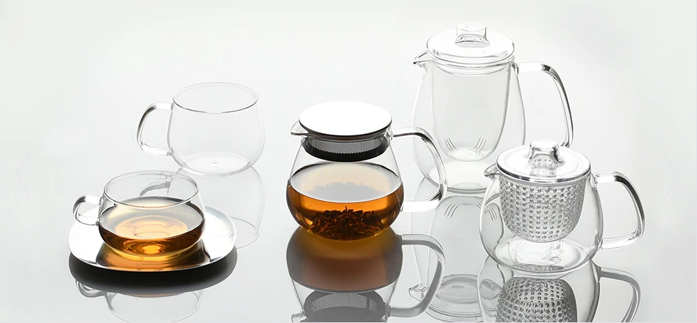 Kinto Unitea theeglas met schotel, afgebeeld tussen andere theeglazen en theepotten