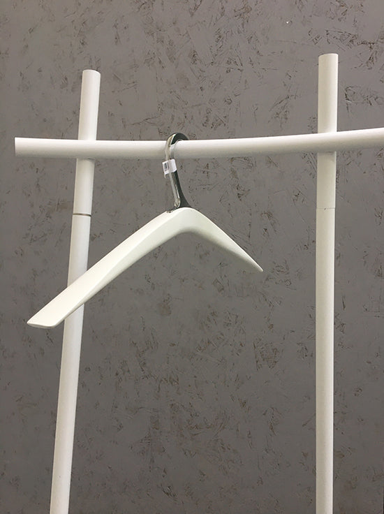 Houten kledinghanger in wit met verchroomde haak, hangend aan kledingrek