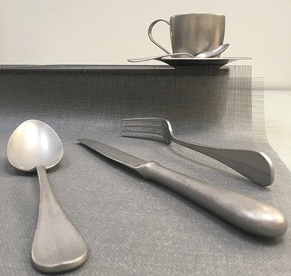 Coffee cup and saucer with matching steel cutlery