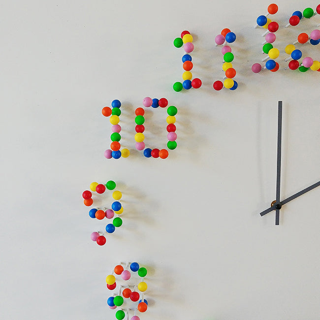 Alessi DiscoDip wandklok, detail van cijfers opgebouwd uit gekleurde bollen