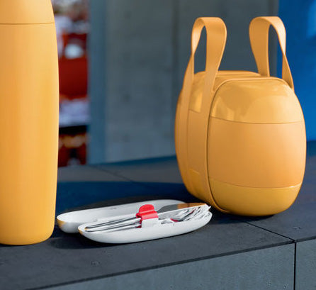Alessi bestekset in geopende ovale box, naast gele lunchbox SA02