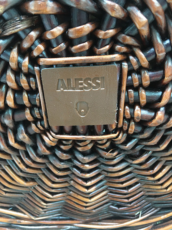 Detail van het Alessi-logo op het leren label van de rieten picknickmand