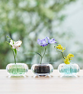 Michi-Kusa vases side by side, three small glass vases with various flowers