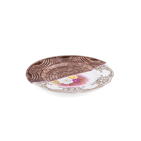 Alessi Hybrid Nok plate, view at an angle, half wood-grain pattern and half floral pattern, from the Hybrid-World series
