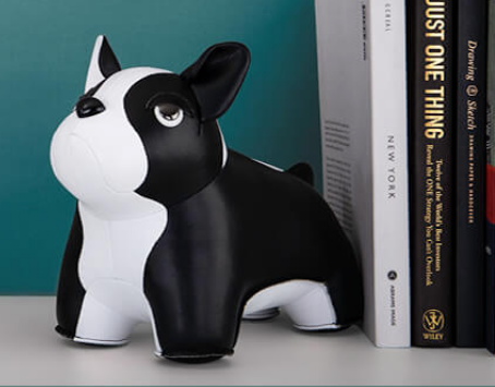 Zuny dierfiguur Franse buldog, zwart-wit, als boekensteun tegen boeken geplaatst