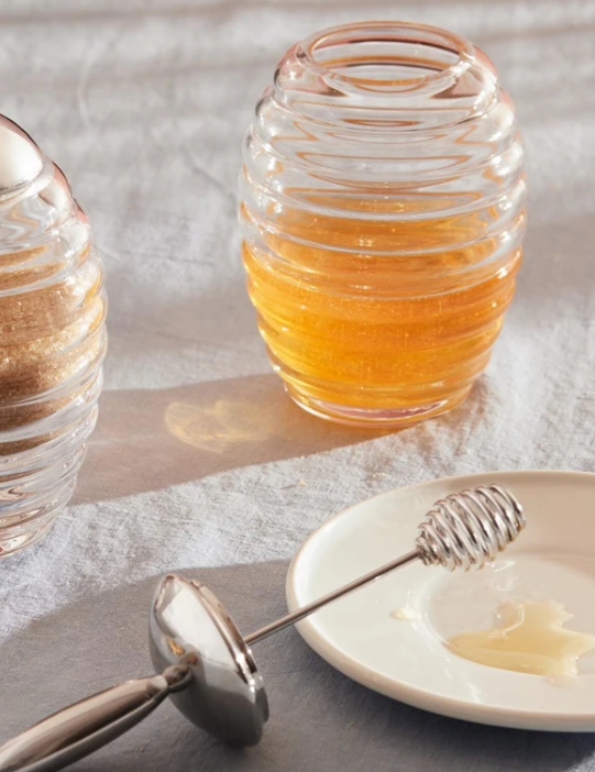 Alessi Honey Pot honingpot van geribbeld glas, gevuld met honing, naast suikerpot voor ontbijt