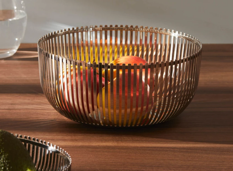 Alessi fruitschaal in gepolijst rvs met verticale staafjes, gevuld met fruit