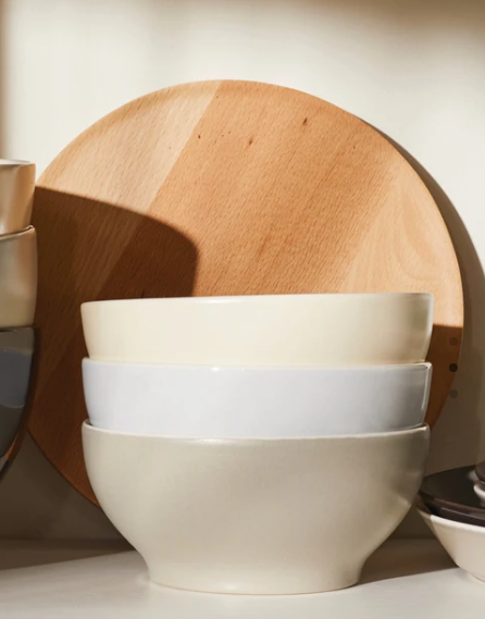 Alessi Tonale ronde plank in beukenhout, achter een stapel kommen