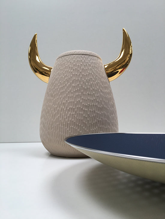 Rim detail of Cohncave bowl in blue and gold, next to a horn-shaped object