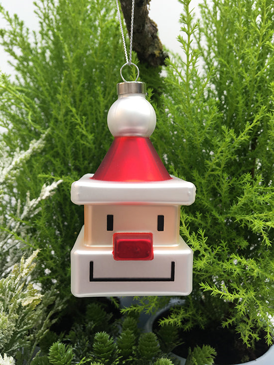 Kerstbal uit de Alessi-serie Santa-Cube, glazen kubus met gezicht en rode punthoed, vooraanzicht