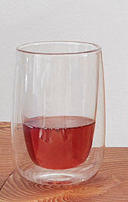 Fundamental Doppler dubbelwandig theeglas, gevuld met rode drank