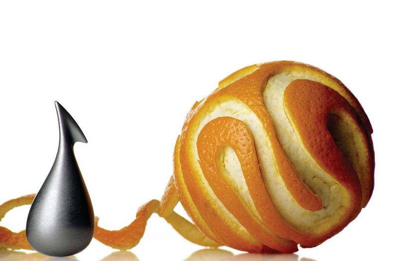 Alessi Apostrophe dunschiller, zijaanzicht, met sinaasappelschil op de achtergrond