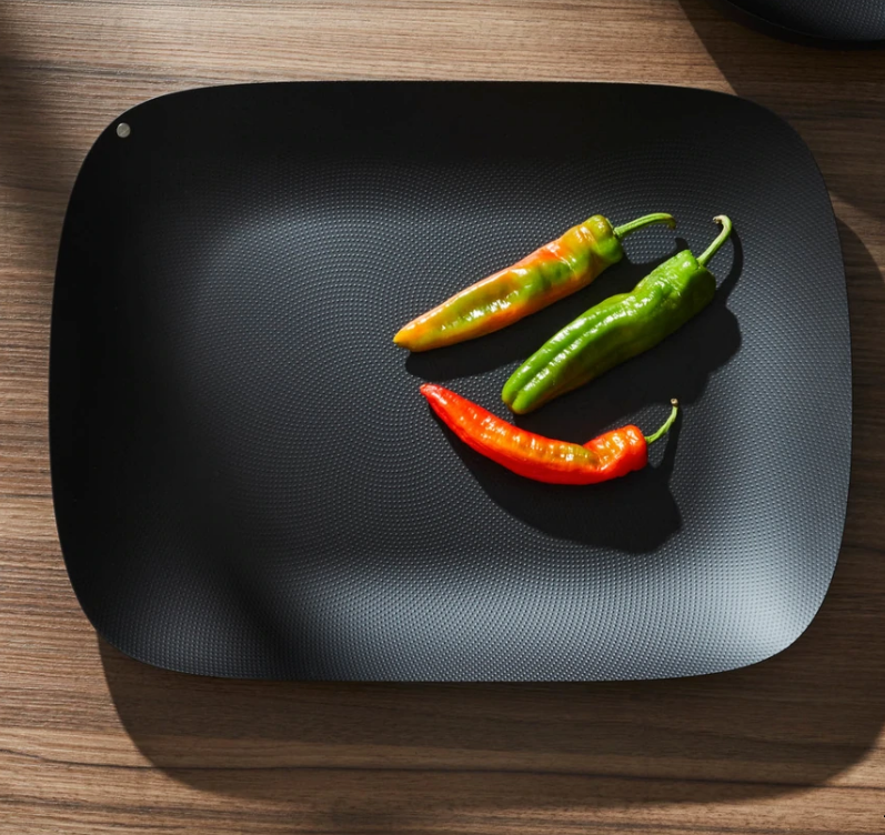 Alessi Moiré schaal in matzwart, met paprika's erop
