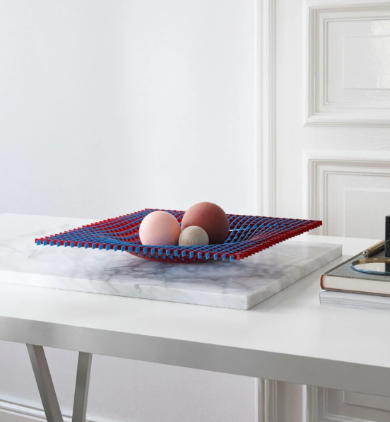Fruitschaal in blauw en rood met eieren op marmeren onderzetter