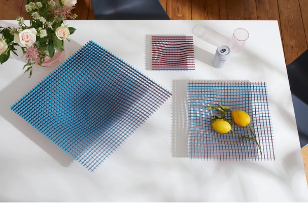 Twee fruitschalen naast elkaar in blauw en rood, met bloemen en citroenen