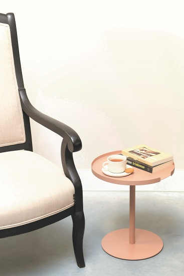 Ronde bijzettafel in oudroze naast fauteuil, met kopje en boeken erop