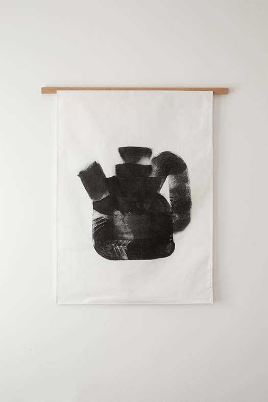 Wanddoek Just a tea pot van Hanna Kooistra, zwarte theepot-afdruk op wit katoen, serie van 50.
