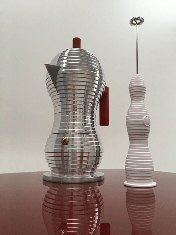 Alessi melk-opschuimer wit, naast pulcina koffiemaker in aluminium en rood