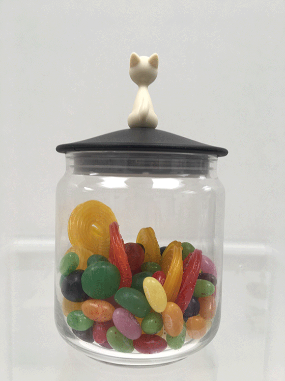 Glass sweets jar with cat figure on lid, filled with sweets