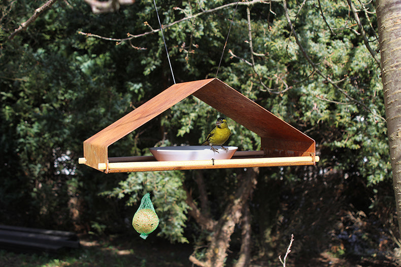Hangend vogelhuis in bungalowstijl, Cortenstaal, met vogel op de rand