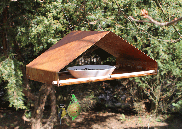 Hangend vogelhuis in bungalowstijl, Cortenstaal, zijaanzicht met vogel bij het voer