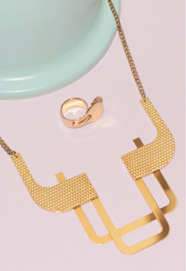 Trama halsketting van Alessi naast bijpassende ring, gouden band met geometrisch patroon