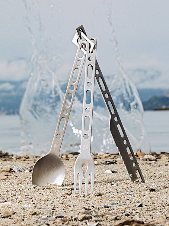 Mes, lepel en vork van de Alessi Occasional Object bestekset rechtop op het strand