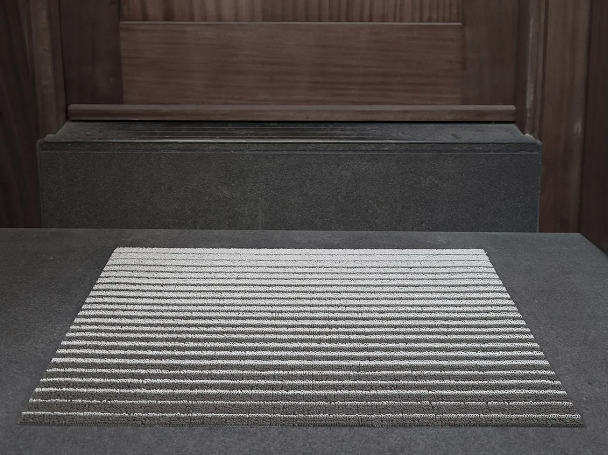 Deurmat Domino Oak van Chilewich, ontworpen door Sandy Chilewich, schuin aanzicht in beige-grijs