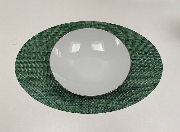 Ovale placemat in groen, mini basketweave structuur, met wit bord erop