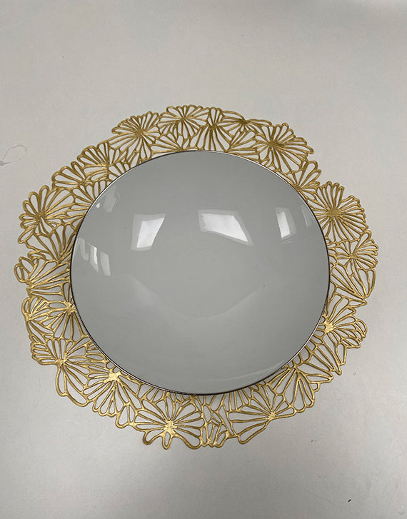 Alessi Daisy Vinyl Gilded, mooie placemat met bloemmotief in goud, met witte schaal erop