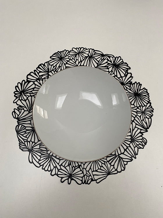 Alessi Daisy placemat in zwart, met witte schaal erop