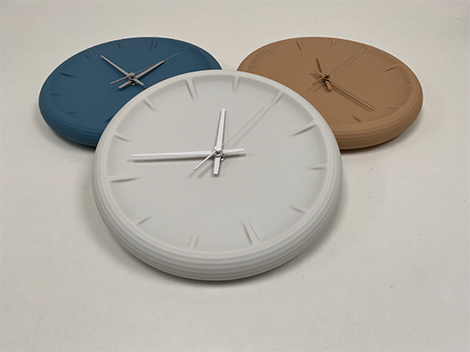 Relief ceramic wall clocks in blue, white and brown side by side