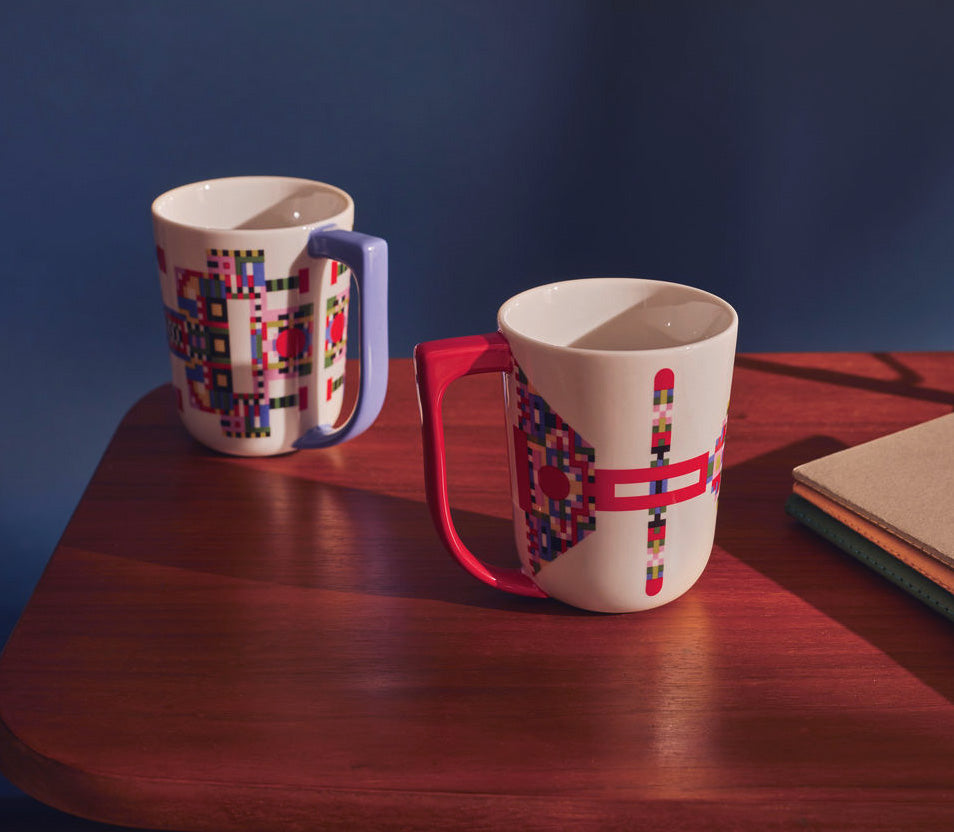 Twee mokken Holyhedrics naast elkaar, met blauw en rood oor