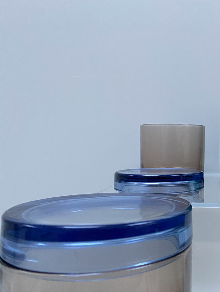 Detail of blue lid on low glass storage jar, brown glass