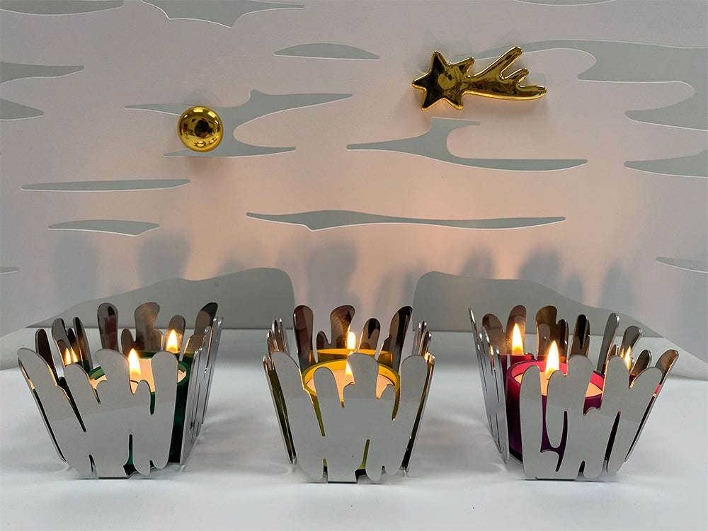 Dot Light waxinelichthouders van Alessi in de Barkandle kerstkandelaars, brandend in diverse kleuren.