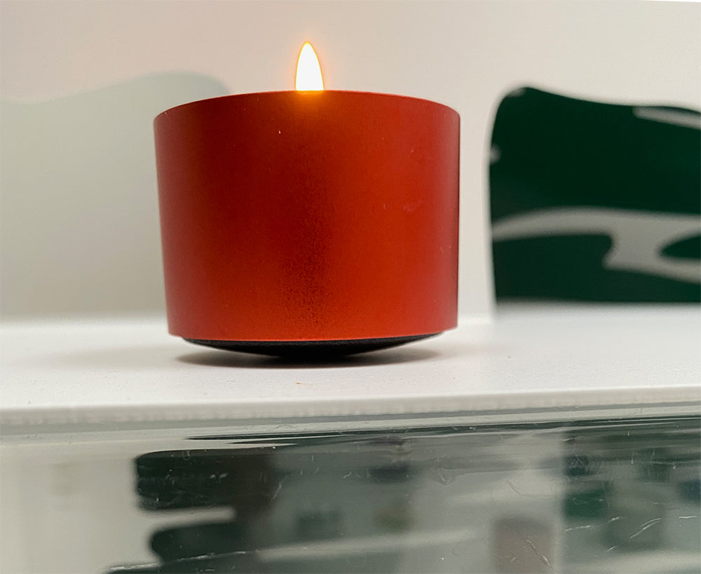 Alessi Dot Light Amber waxinelichthoudertje, geanodiseerd aluminium, brandend.
